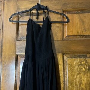Black dress new with tags . Dress 👗 ties around neck . Very stretchy material.